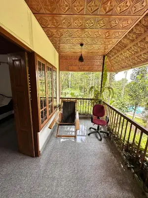 a porch of a house with a chair and a ceiling at Avocado Orchards - Home Stay in Kenichira