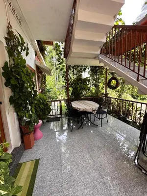 a patio with a table and chairs on a balcony at Avocado Orchards - Home Stay in Kenichira