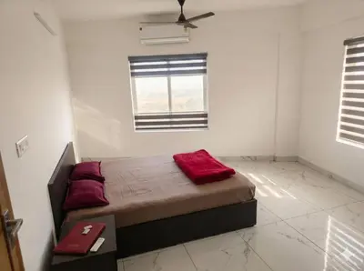 a bedroom with a bed with red pillows and a window at SAIS LINE Residency in Kozhikode