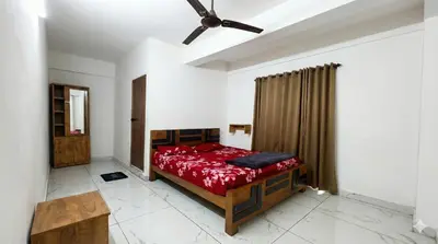 a bedroom with a bed and a ceiling fan at SAIS LINE Residency in Kozhikode