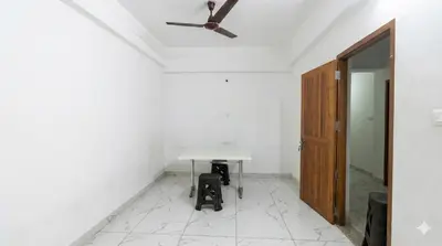 a room with a table and a ceiling fan at SAIS LINE Residency in Kozhikode