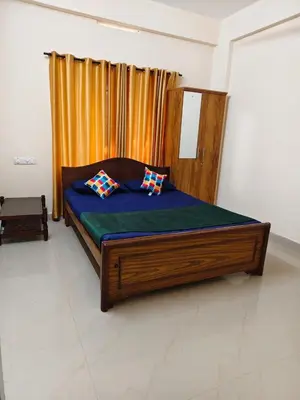 a bed with two pillows on it in a room at Sri Parthasarathy Inn in Guruvāyūr