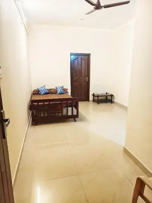a room with a table and a ceiling fan at Sri Parthasarathy Inn in Guruvāyūr