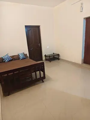 a room with a bed and a door in it at Sri Parthasarathy Inn in Guruvāyūr