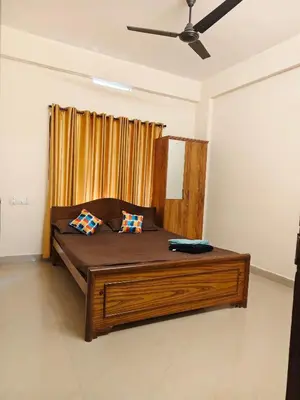 a bedroom with a large bed with two pillows at Sri Parthasarathy Inn in Guruvāyūr
