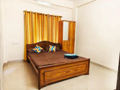 a bed with two pillows on it in a room at Sri Parthasarathy Inn in Guruvāyūr