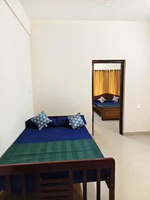 a bedroom with a bed and a mirror at Sri Parthasarathy Inn in Guruvāyūr