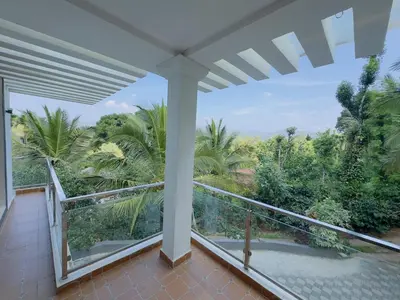 a balcony with a view of the jungle at WhiteLilys Pool Retreat Kaggodlu Madikeri Coorg in Madikeri