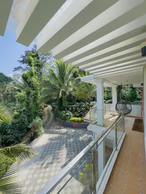 a balcony of a house with a roof at WhiteLilys Pool Retreat Kaggodlu Madikeri Coorg in Madikeri