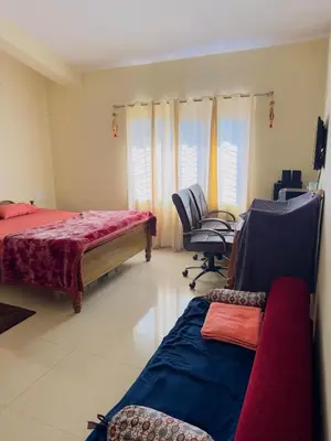 a bedroom with two beds and a desk and a chair at Whitelily's Amrithasthanam in Madikeri