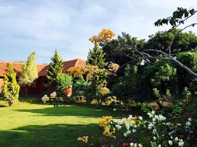 a house with a yard with trees and grass at Tranquilandia in Varagampadi