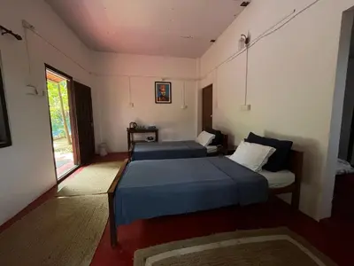 a bedroom with two beds and a window at Tranquilandia in Varagampadi