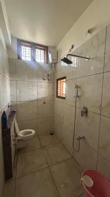a bathroom with a shower and a toilet in it at Aalaya in Mysore