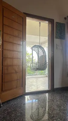 a door leading to a room with a swing at Aalaya in Mysore