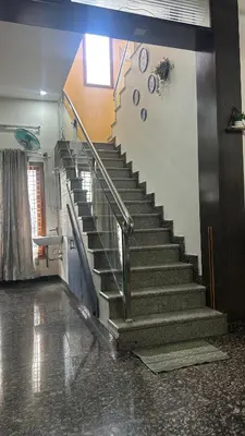 a staircase in a building with a clock on the wall at Aalaya in Mysore