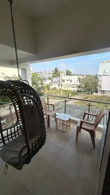 a porch with a hammock and chairs on a balcony at Aalaya in Mysore