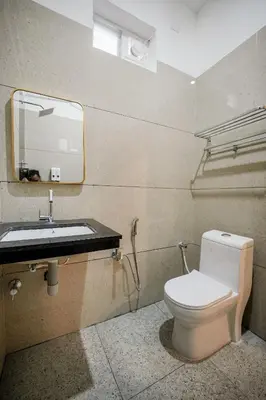 a bathroom with a toilet and a sink at Kayalresidency in Gopichettipālaiyam