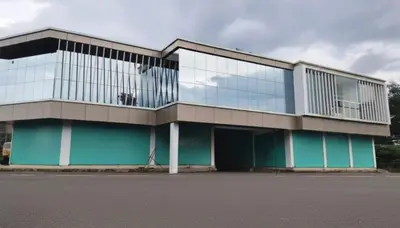 a large building with glass windows on a street at Zeekka Tourist Home in Meenangadi
