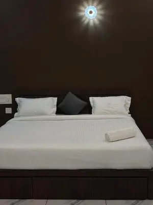 a large white bed with a light above it at Zeekka Tourist Home in Meenangadi