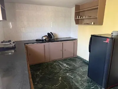 a kitchen with a black refrigerator in a room at Cheerful - homes Mysore stay in Mysore