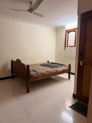a wooden bed in a room with a window at Cheerful - homes Mysore stay in Mysore