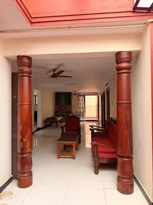 a living room with two large wooden columns in a house at Cheerful - homes Mysore stay in Mysore