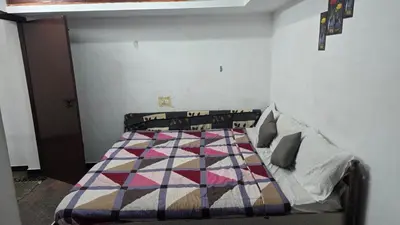 a bedroom with a bed with a quilt on it at Ooty Individual Villa in Ooty