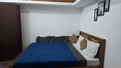 a bedroom with a bed with blue sheets and pillows at Ooty Individual Villa in Ooty