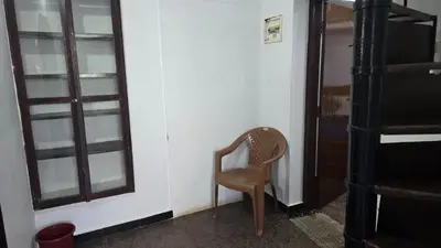 a wooden chair sitting in a room next to a door at Ooty Individual Villa in Ooty
