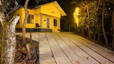 a porch of a yellow house at night at Vihara Inn Resort in Vayittiri