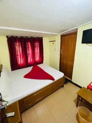 a bedroom with a large bed with a red window at budget stay-mystique inn in Ooty