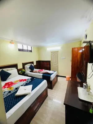 a hotel room with two beds and a desk at budget stay-mystique inn in Ooty