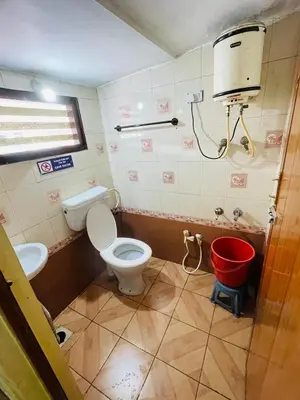 a bathroom with a toilet and a bucket at budget stay-mystique inn in Ooty