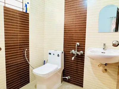 a bathroom with a toilet and a sink at Anandha Vibes STAY blessed in Guruvāyūr