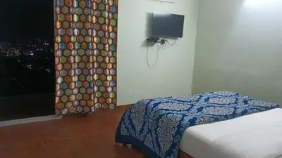 a bedroom with a bed and a window with a curtain at RS Hollidays ooty in Ooty