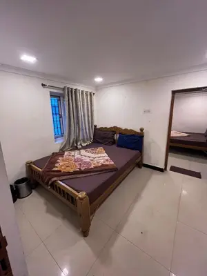 a bedroom with a bed in a room with a mirror at RS Hollidays ooty in Ooty