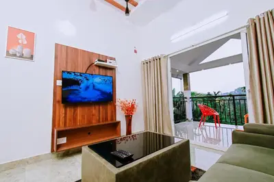 a living room with a tv and a couch at Alora villas in Wayanad