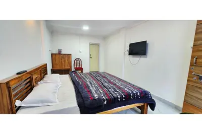 a bedroom with a bed with a blanket on it at Kitty Royal Inn in Ooty