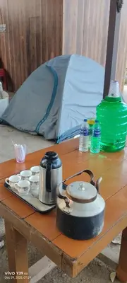 a table with a tea kettle and cups on it with a tent at Wild Ni8 Club