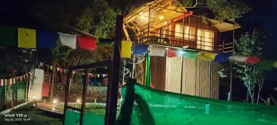 a fence with prayer flags and a house at night at Wild Ni8 Club