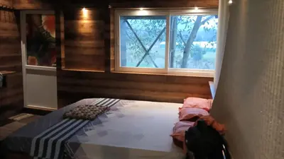 a bedroom with a bed and two windows at Wild Ni8 Club