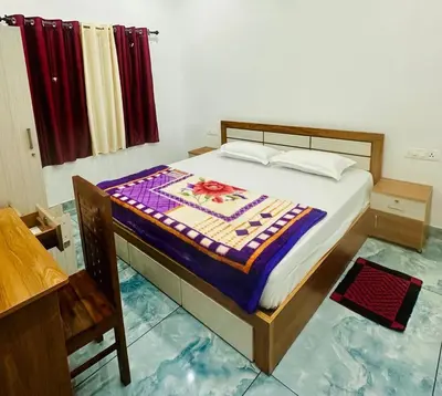 a bedroom with a bed with a colorful quilt on it at Zonooro Homestay Vythiri in Vythiri