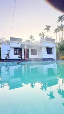 a house with a swimming pool in front of a house at Grand Glorious Resort in Padinjarathara