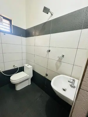 a bathroom with a toilet and a sink at Grand Glorious Resort in Padinjarathara