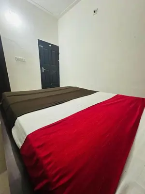 a bed with a red and white blanket on it at Grand Glorious Resort in Padinjarathara