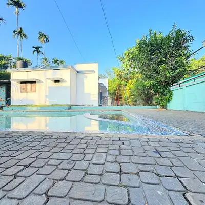 a swimming pool in front of a house at Grand Glorious Resort in Padinjarathara