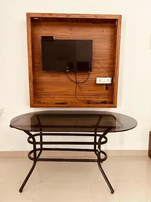 a table with a tv on top of a wall at Grand Glorious Resort in Padinjarathara