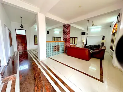 a living room with a red couch and a fireplace at The 77 Estate Stay in Suntikoppa