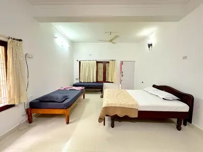 a bedroom with two beds and a window at The 77 Estate Stay in Suntikoppa