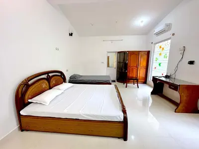 a bedroom with a bed and a desk at The 77 Estate Stay in Suntikoppa